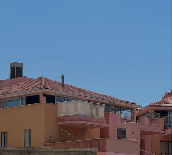 Pink residential building beneath a clear blue sky