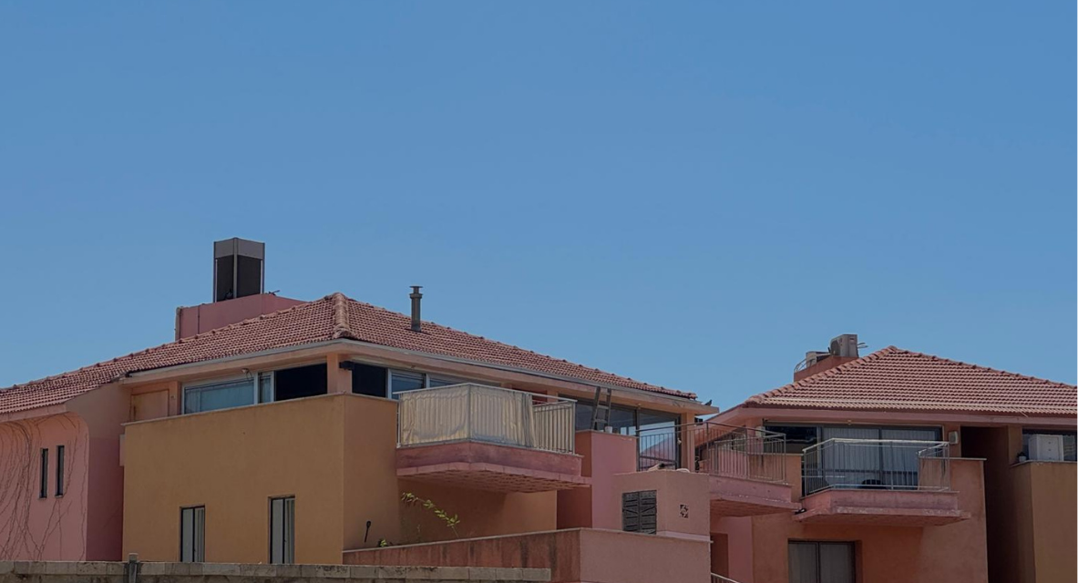 Pink residential building beneath a blue sky