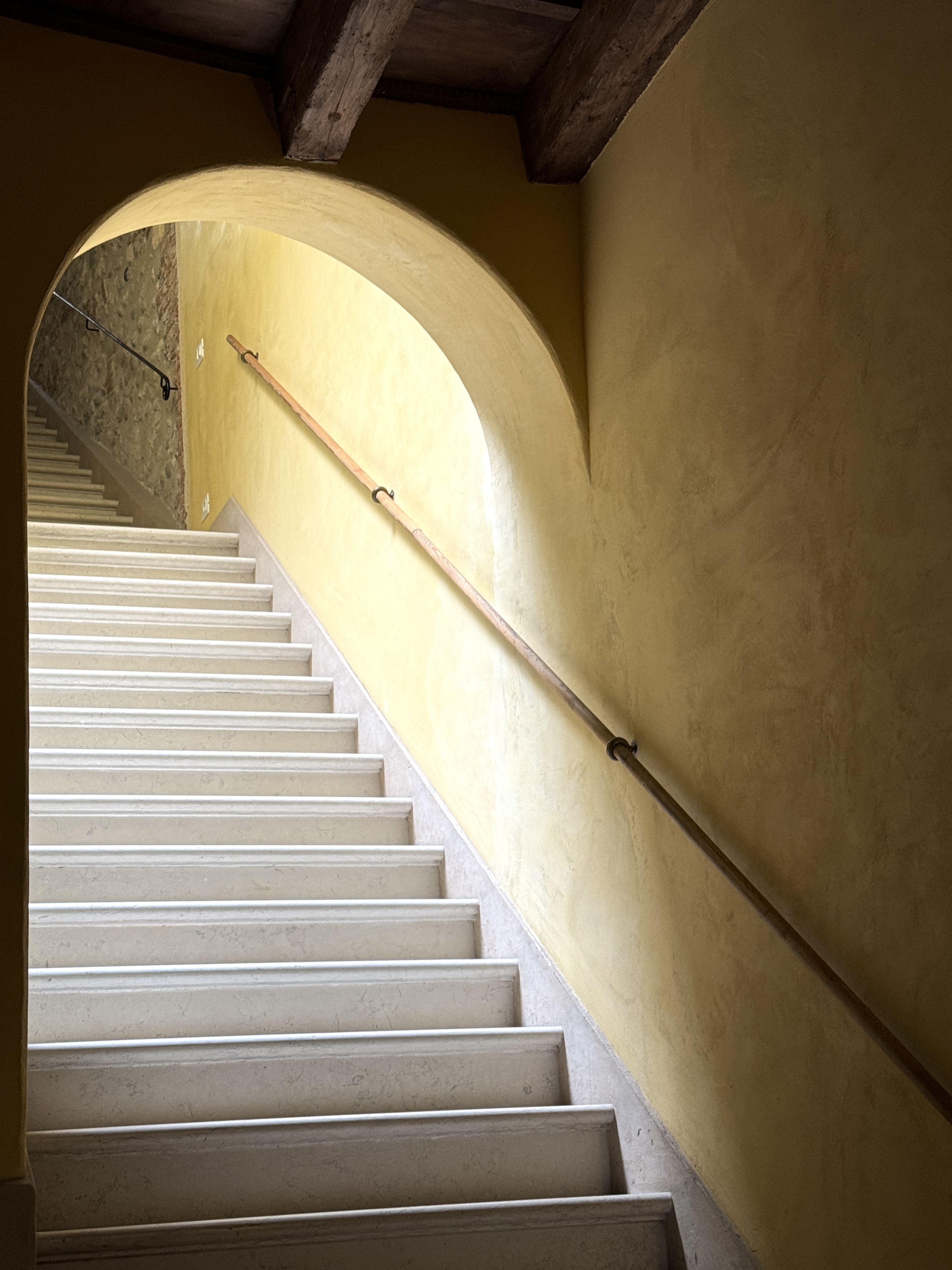 Sunlit staircase beneath a rounded arch